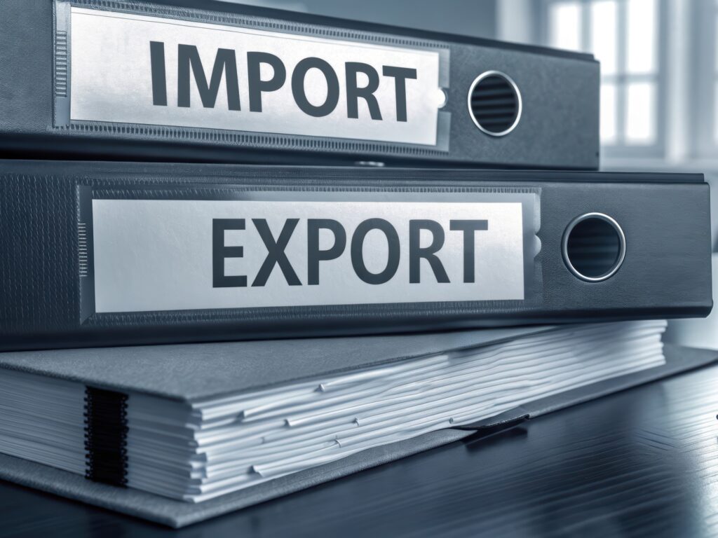 Stack of binders with the words Import and Export on the spines.