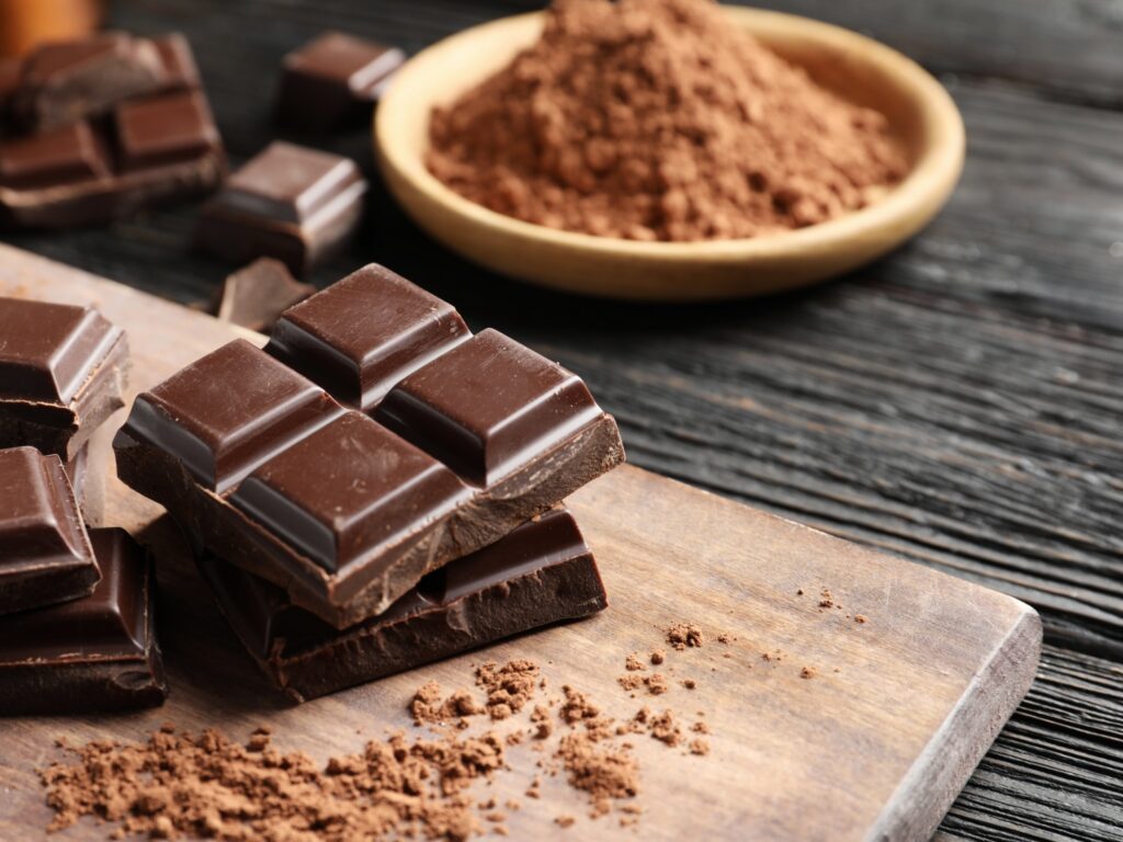Pieces of black chocolate on wooden board